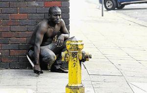 KNIFE EDGE: An immigrant waits for gangs of locals that attacked foreign shop owners in the Durban city centre yesterday. At least three people were stabbed and one burnt. Image by: TEBOGO LETSIE